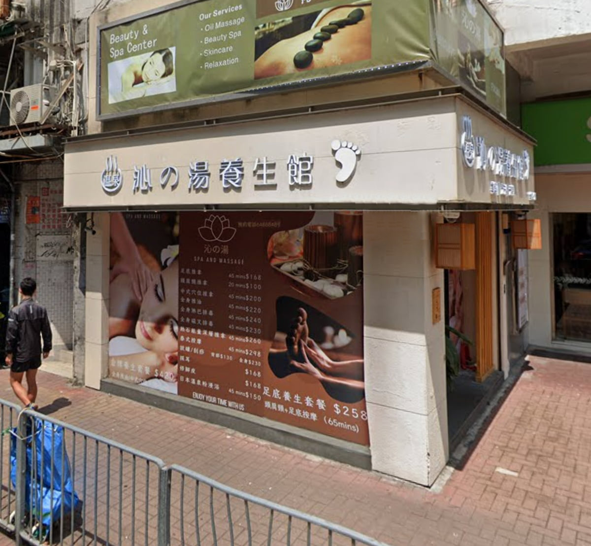 Street view of a massage and spa center on Kwong Fuk Road with signs and window images depicting massages.