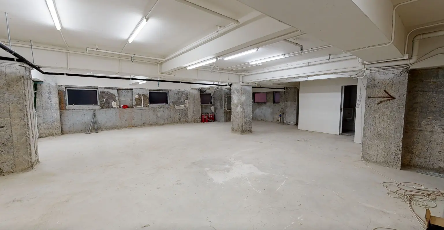 Shop on Wellington Street, Central. Unfinished basement on Central Wellington Street with concrete floors, exposed pipes, and small windows along the walls.