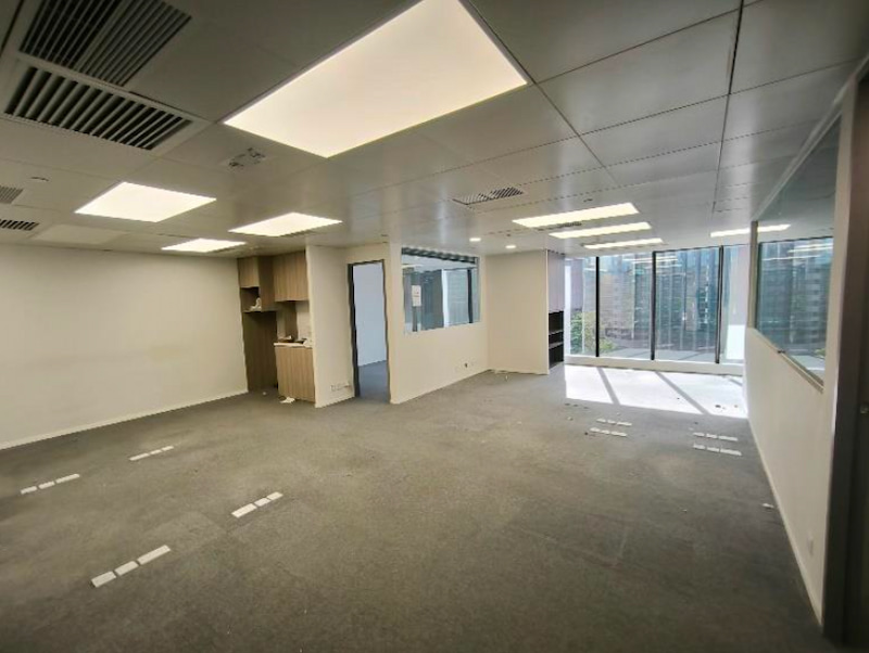 Office on Granville Road, Tsim Sha Tsui. Carpeted office with glass walls, shelves, and large windows letting in natural light.