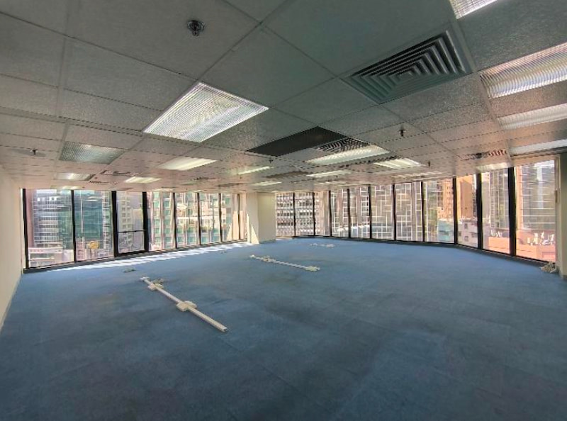 Office on Granville Road, Tsim Sha Tsui. Empty office space with blue carpet, ceiling lights, large windows, and Granville Road views.