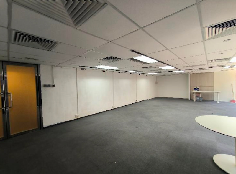 Office on Granville Road, Tsim Sha Tsui. Office room with gray carpet, glass door, and a table with supplies in the back corner.