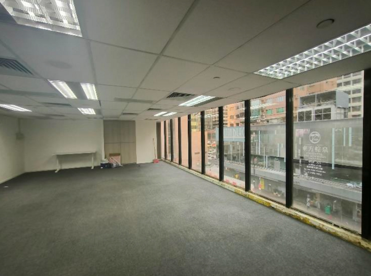 Empty office space with gray carpet, large windows, and city views on Granville Road in Tsim Sha Tsui.