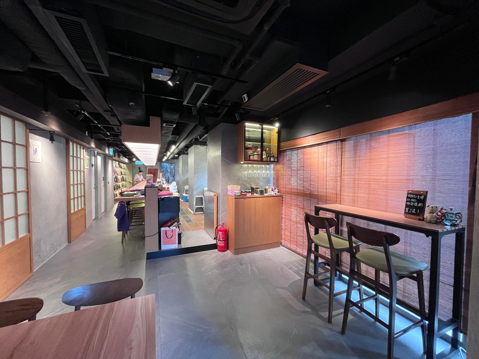 Modern restaurant interior on Wellington Street Central with wooden tables bar seating by the window and a counter.