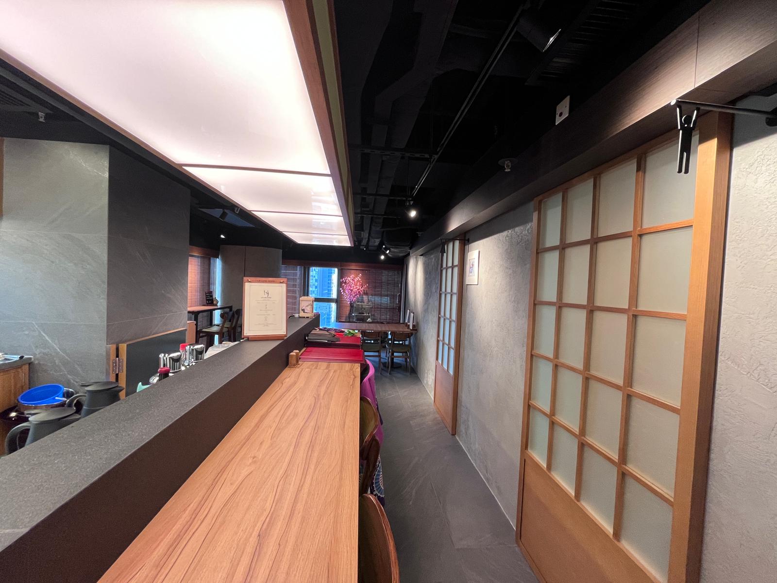 Modern restaurant on Wellington Street with a wooden counter, sliding doors, and tables beneath ceiling lights.