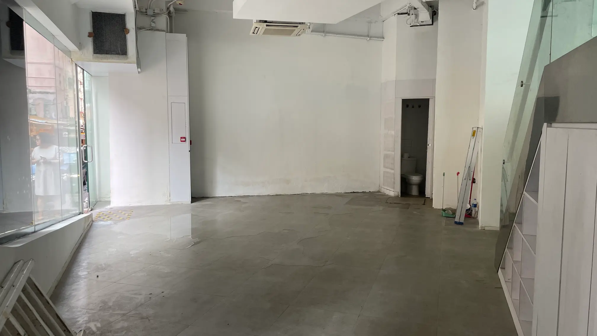 Commercial unit on Queens Road West Sai Ying Pun features glass windows plain walls and a small restroom.