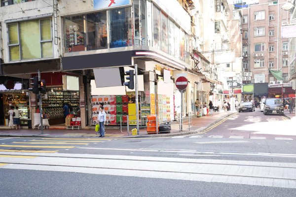 Percival Street in Causeway Bay with shops, pedestrians crossing at crosswalks, and a delivery truck during the day.