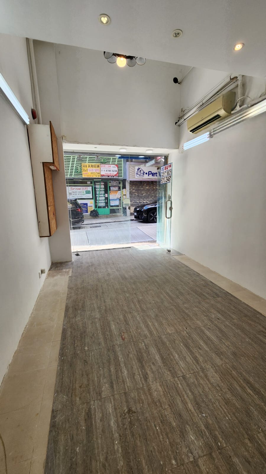 Shop on Third Street, Sai Ying Pun. Storefront with white walls, wood flooring, glass door, and view of the street outside.