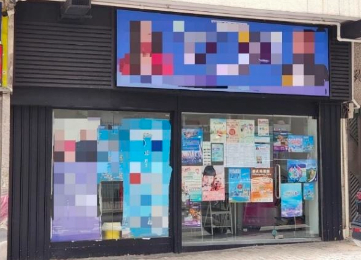 Storefront on Caine Road with posters and signs in the windows; exterior images appear pixelated.