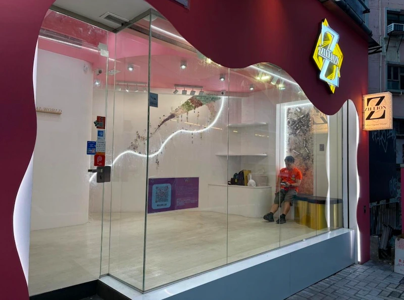 Shop on Caine Road, Mid-Levels. A person sits alone in a small modern glass-walled room with minimal decor.