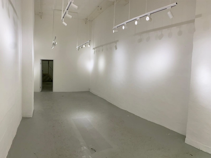 Shop on Wyndham Street, Central. Gallery room, with white walls, track lighting, and an open doorway at the back.