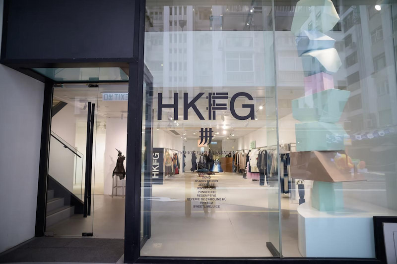 Street view of HKFG clothing store with Hong Kong Designers’ garments visible through the glass storefront.
