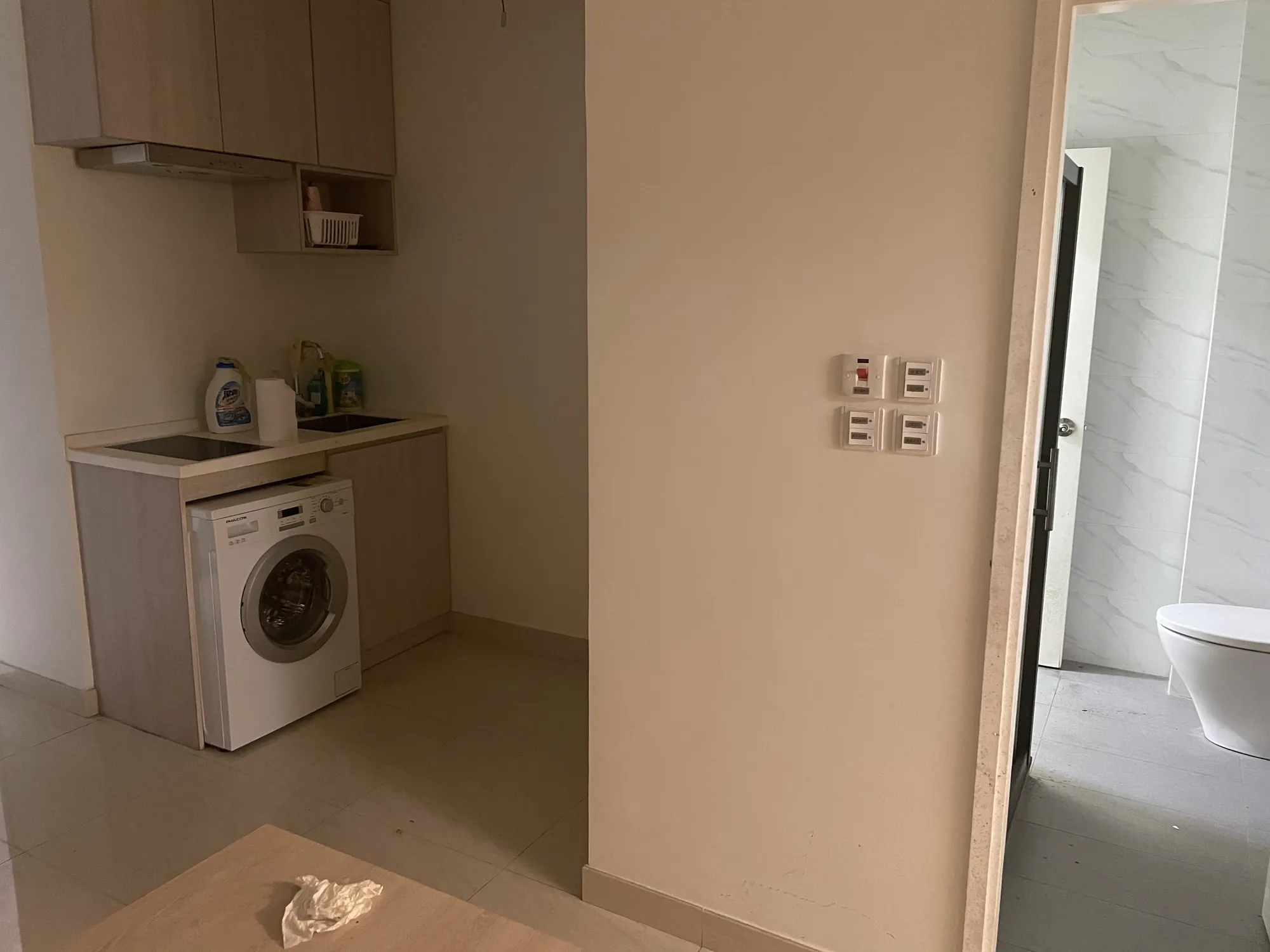Laundry area with washing machine, sink, cleaning supplies, and bathroom near Central on Hollywood Road.