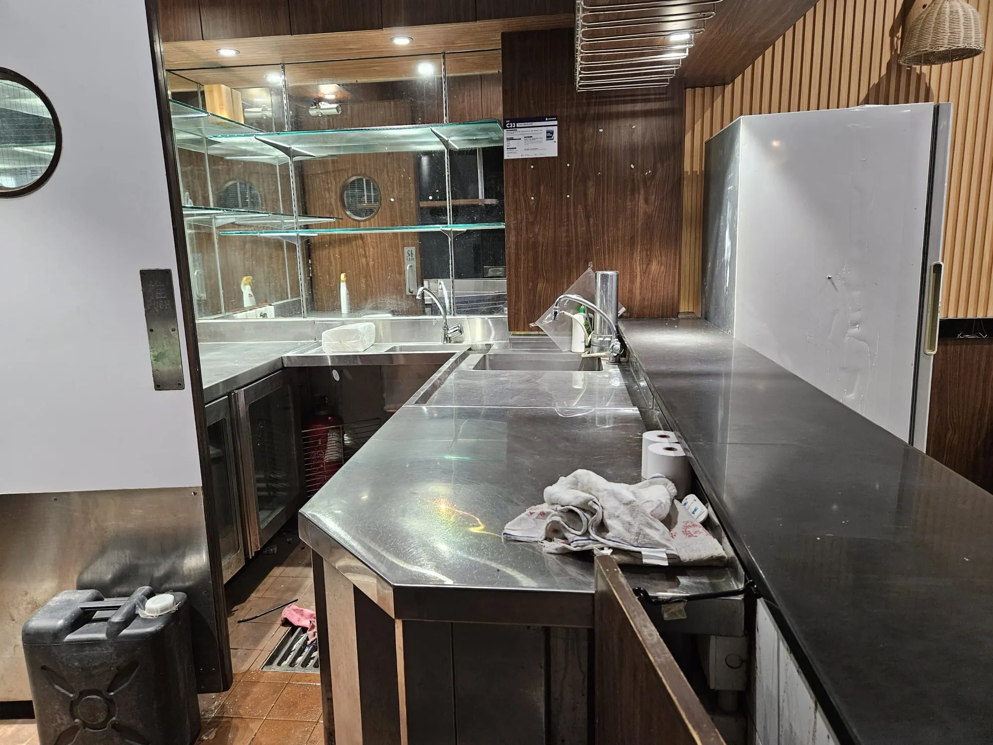 Commercial kitchen on Hau Wo Street, Kennedy Town with stainless counters, a refrigerator and mirrored wall.
