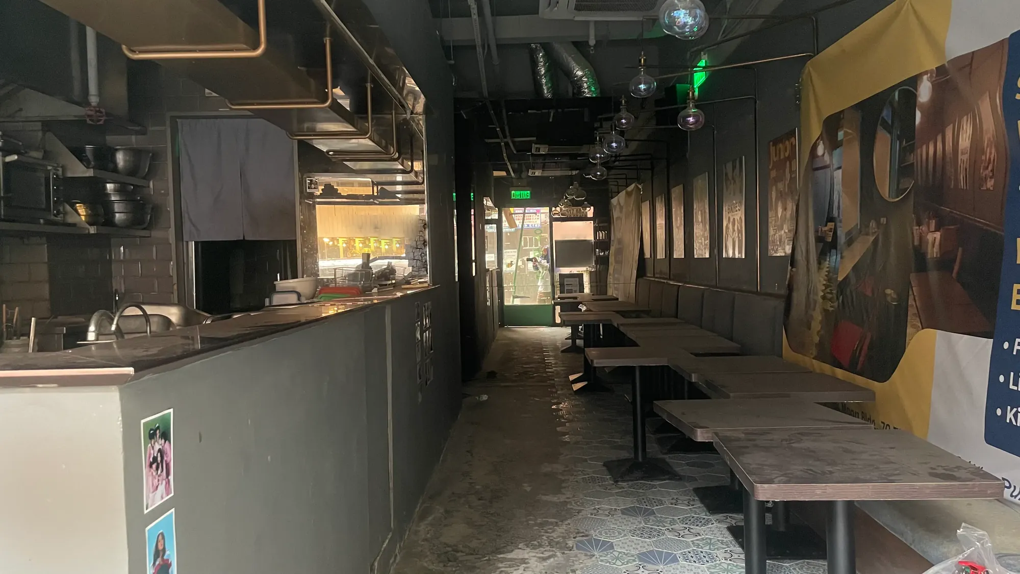 Empty restaurant interior on Third Street, Sai Ying Pun with tables lined up, chairs stacked and entrance visible at the end.