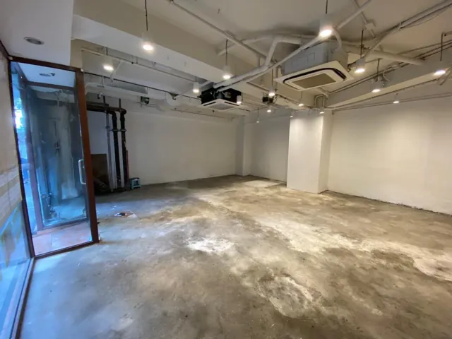 般咸道一個空置舖位，設有水泥地面、白牆、大窗戶及外露天花喉管。