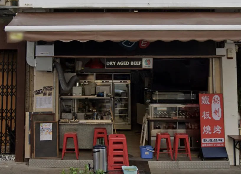 Shop on Ki Lung Street, Sham Shui Po. Small restaurant with dry-aged beef sign, red stools, and Chinese menu board outside.