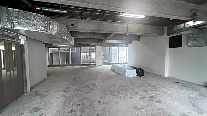 Restaurant space at H Code, Central – bare-shell interior with exposed ceiling services