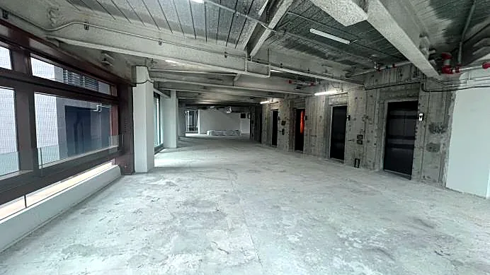 Restaurant space at H Code, Central – open bare-shell floor plate looking towards the lift core