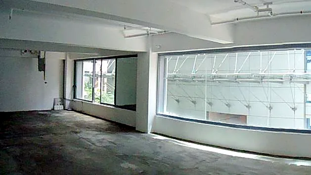 Office at W Place, Central. Open floor plate with a long window line along the front.