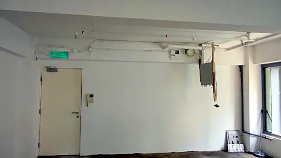 Office at W Place, Central. Entrance side of the floor with exit door.
