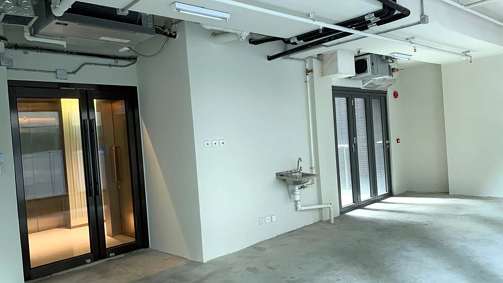 Open shell office looking toward lobby entrance and terrace doors, Central