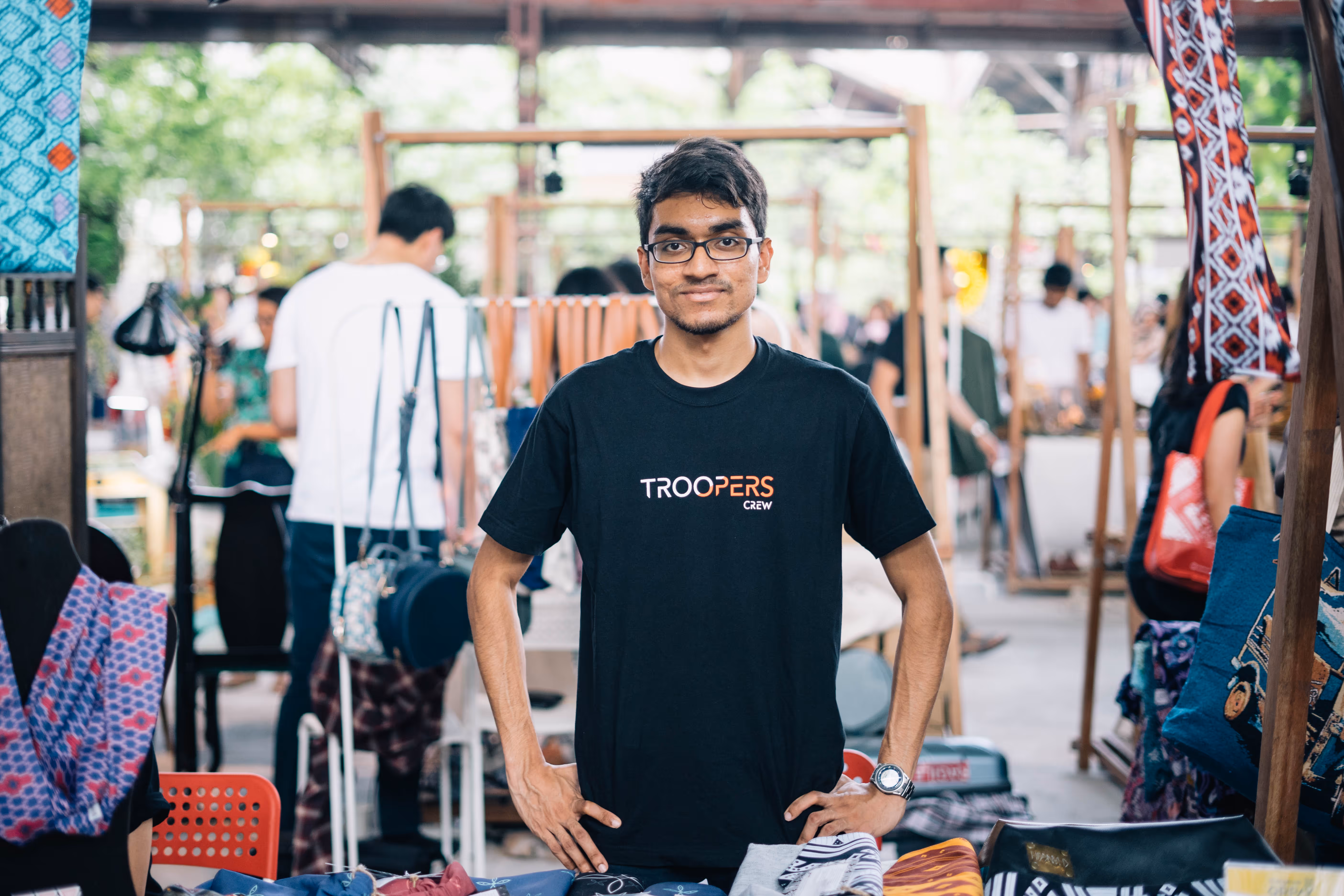 TROOPERS crew member at a vibrant marketplace, representing the commitment to transparency in gig worker wages.
