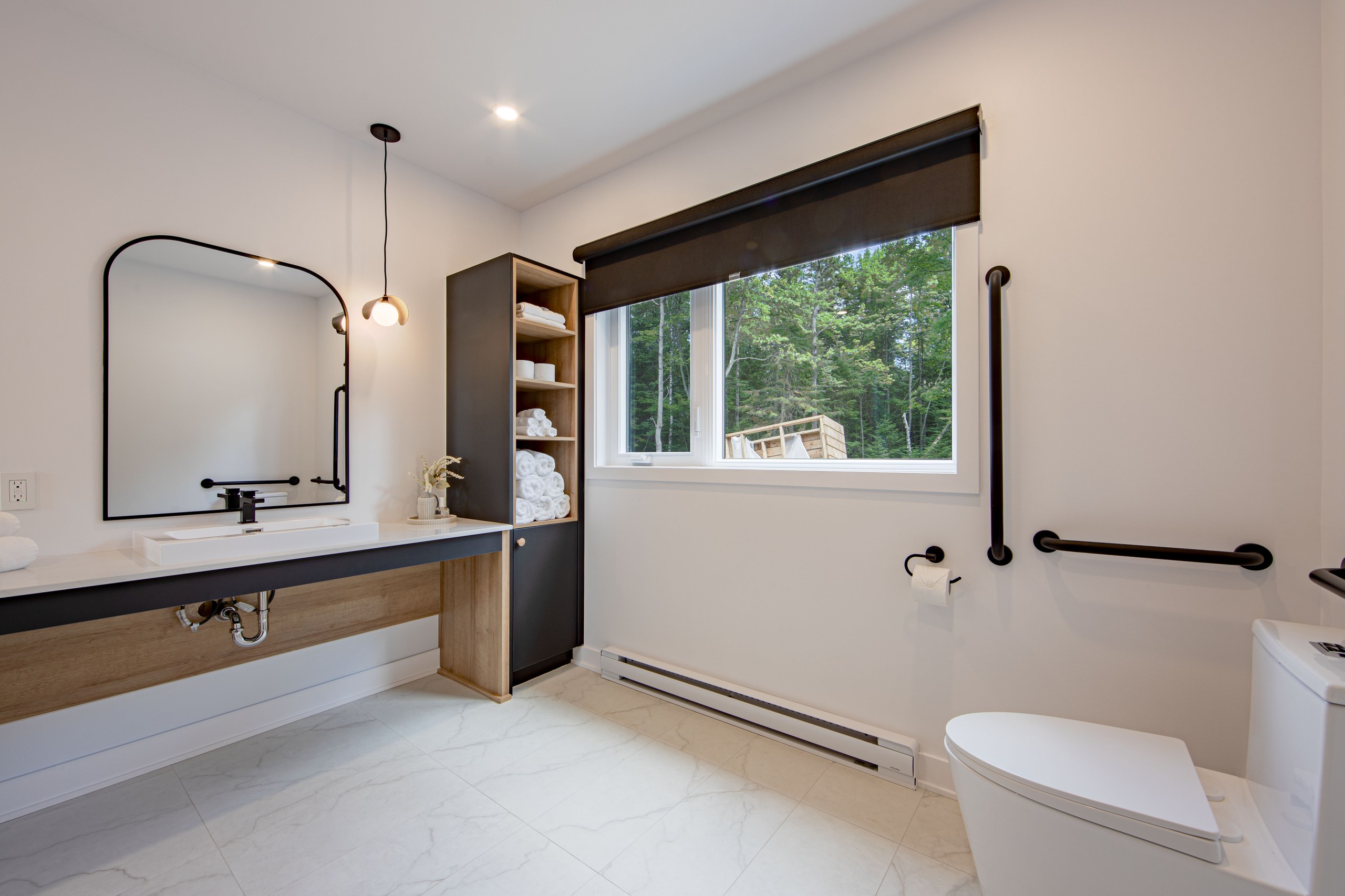 Chalet Le Boréal salle de bain adaptée barres d’appui vanité accessible toilette sécurisée et carrelage marbré