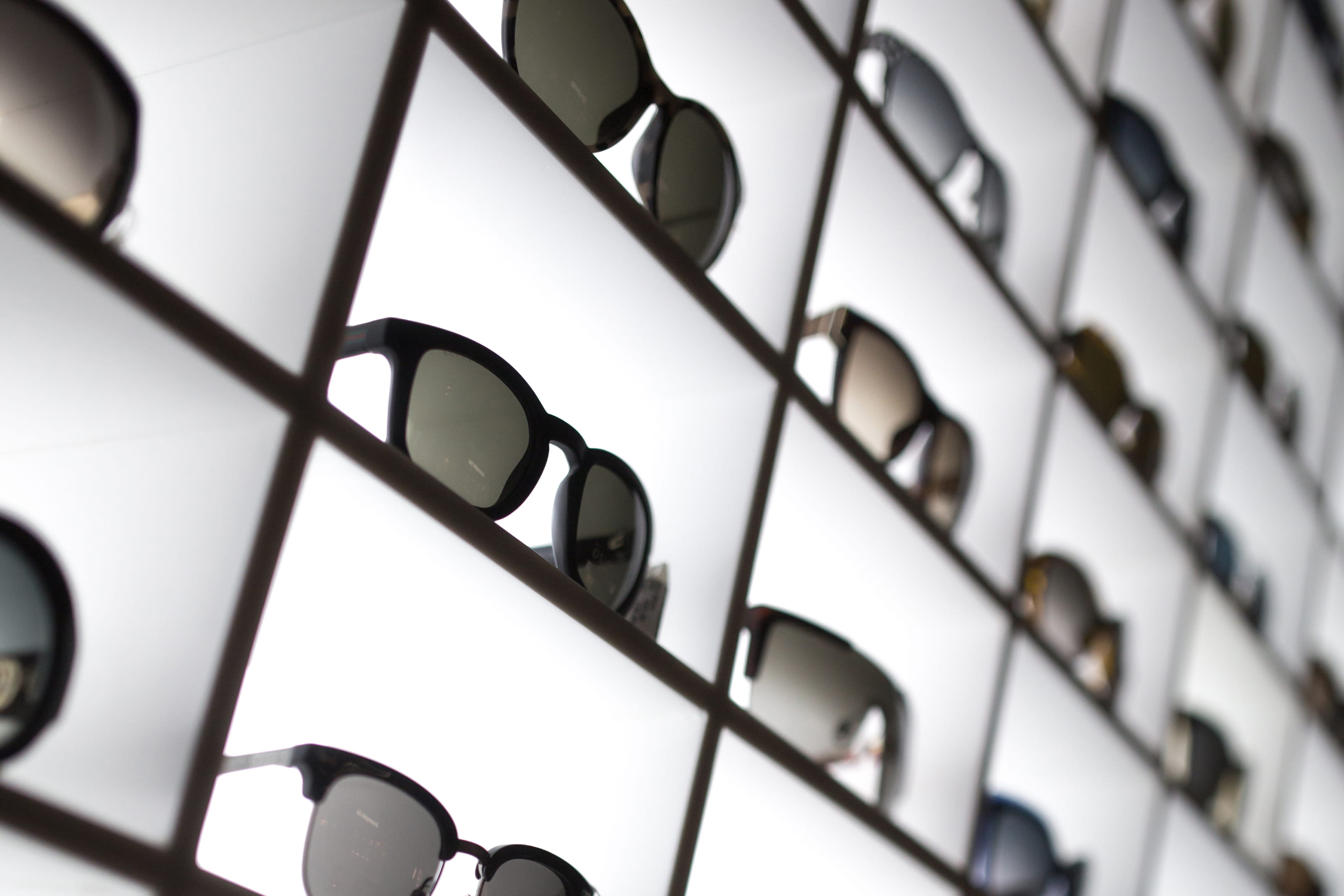 Multiple sunglasses with dark lenses arranged diagonally on white background