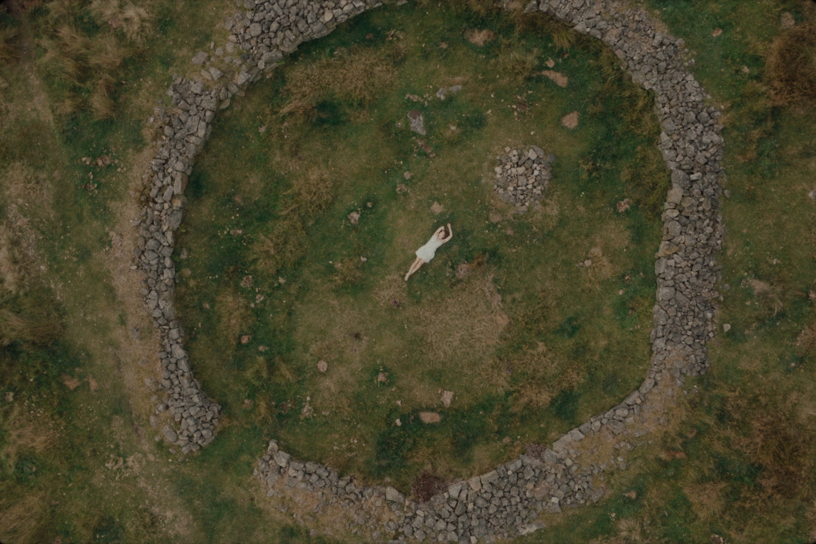 Shot from above of Monqi lying in a stone circle