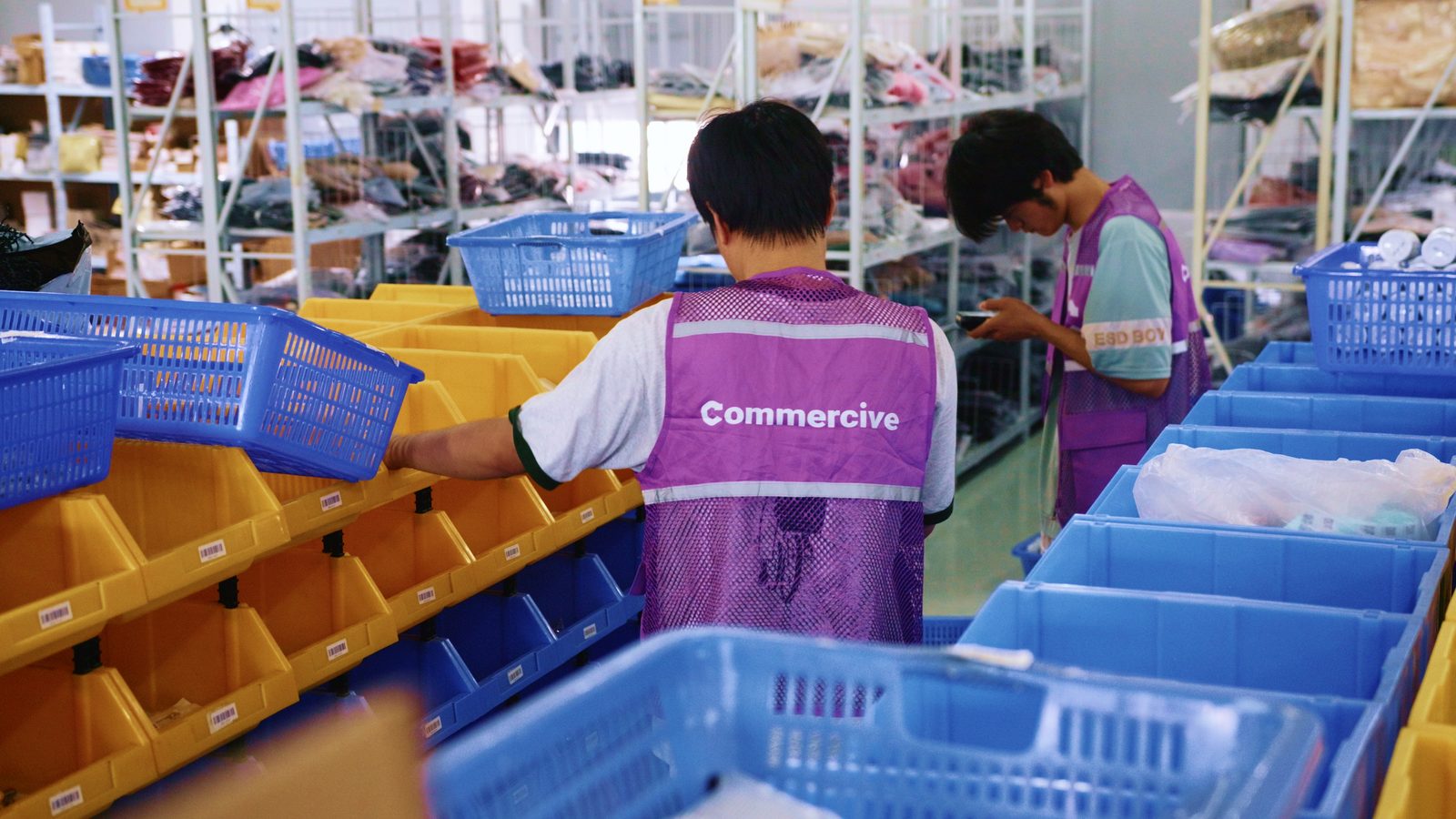 Commercive staff sorting orders into barcoded picking bins on the warehouse floor