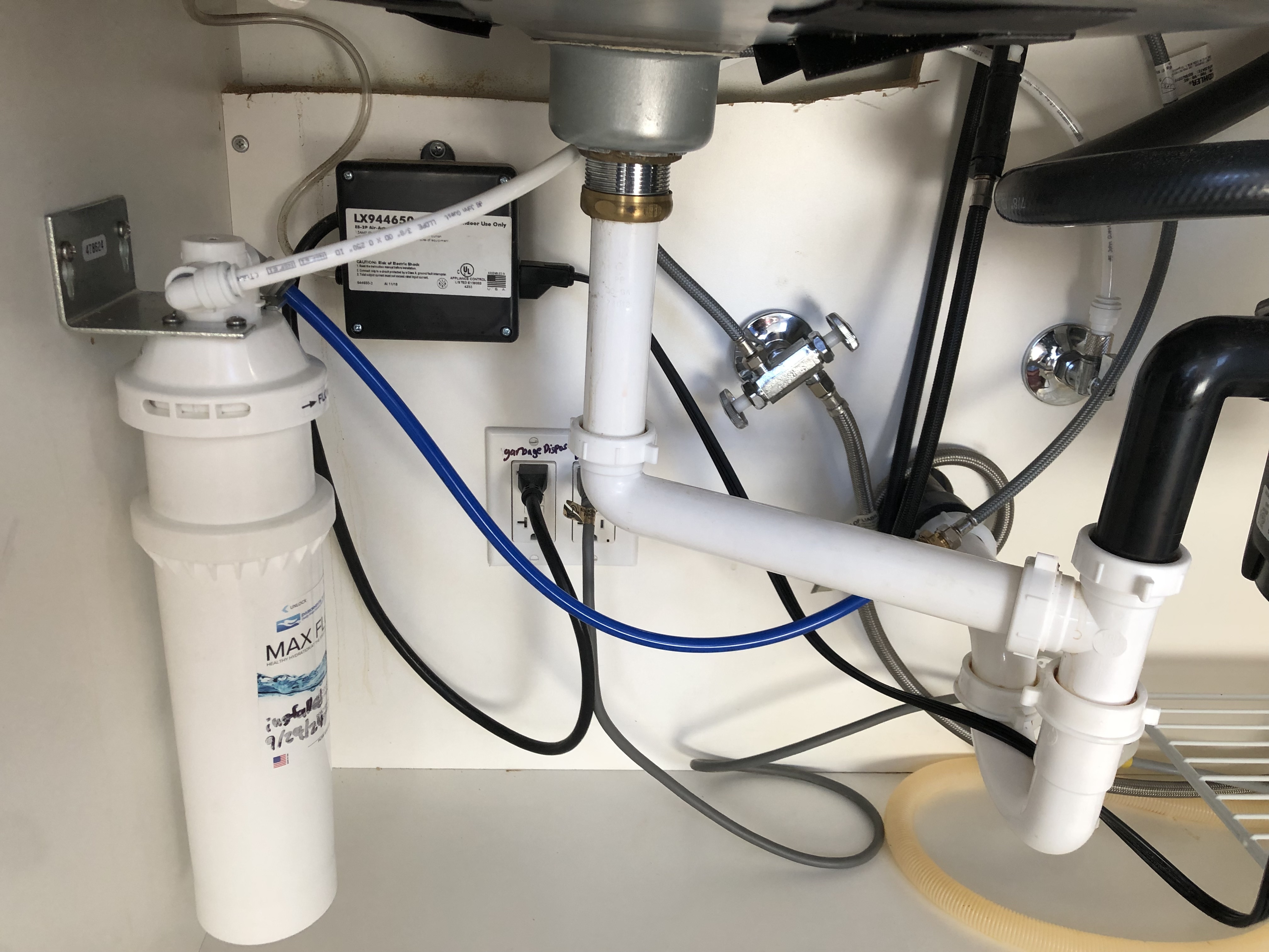 Kitchen sink drain lines, showcasing clean chrome and a p-trap, symbolic of plumbing and showcasing professional installation and maintenance services.