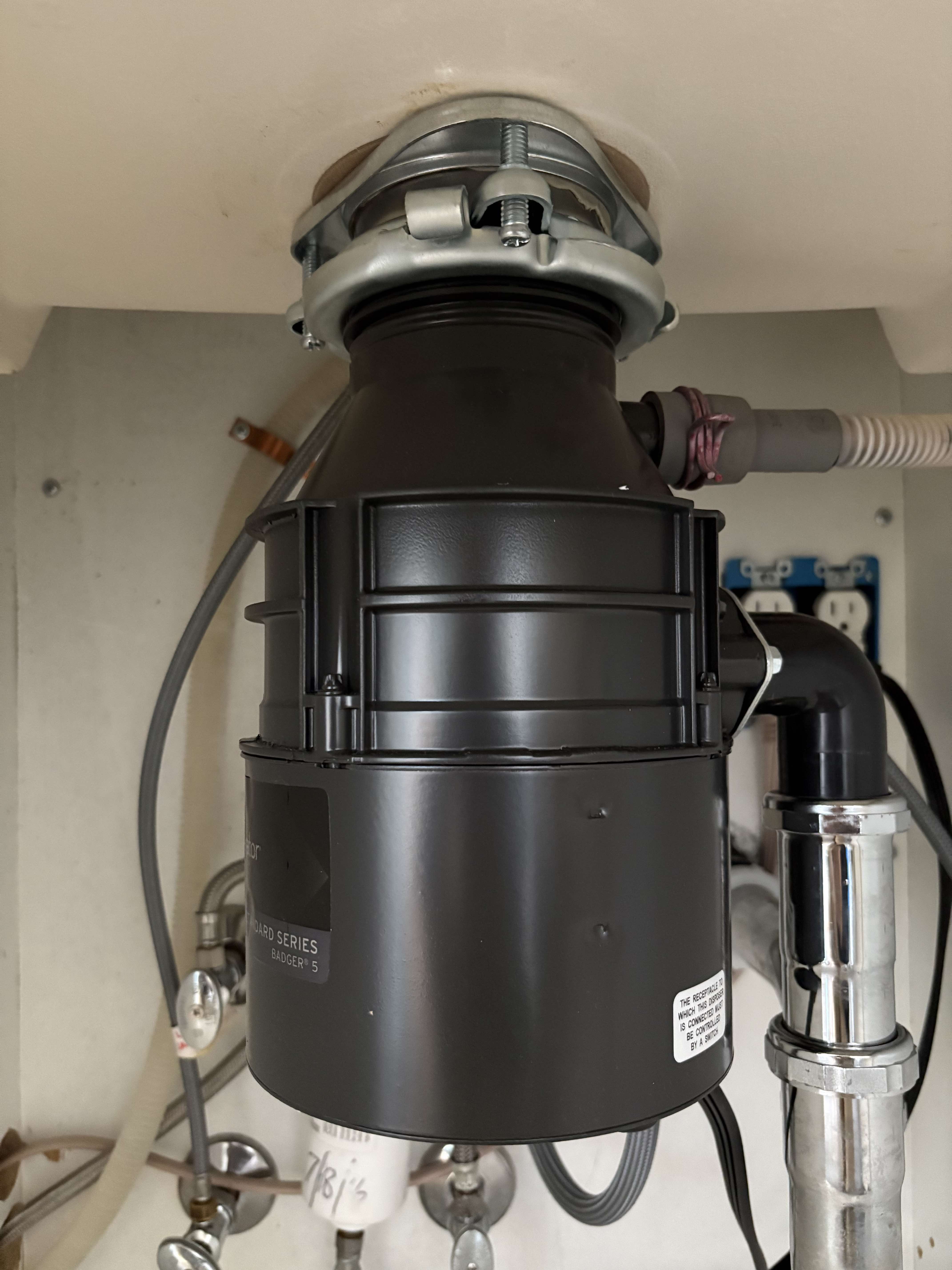 Kitchen sink drain lines, showcasing clean chrome and a p-trap, symbolic of plumbing and showcasing professional installation and maintenance services.