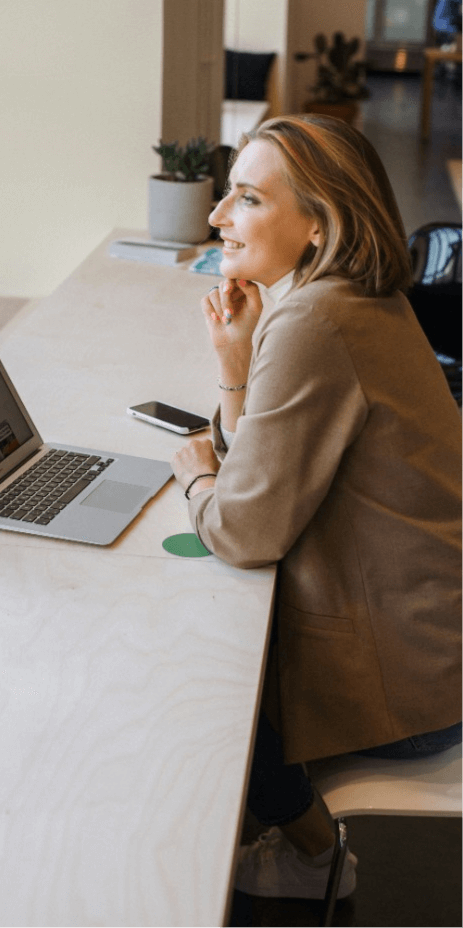 woman in brown coat using macbook air