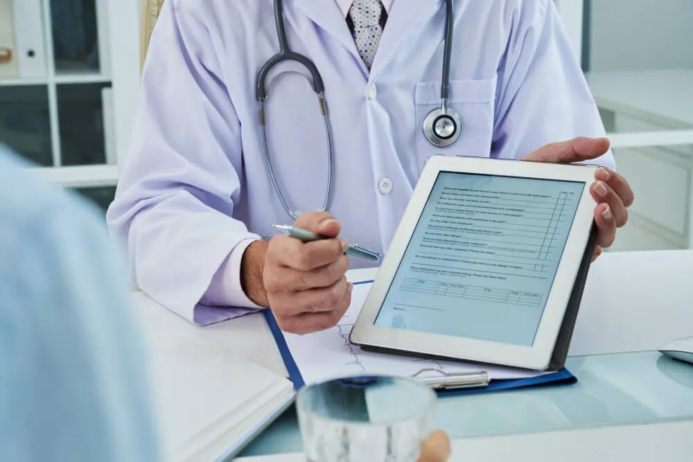 A doctor extending the digital tab for patient to fill in the questionnaire