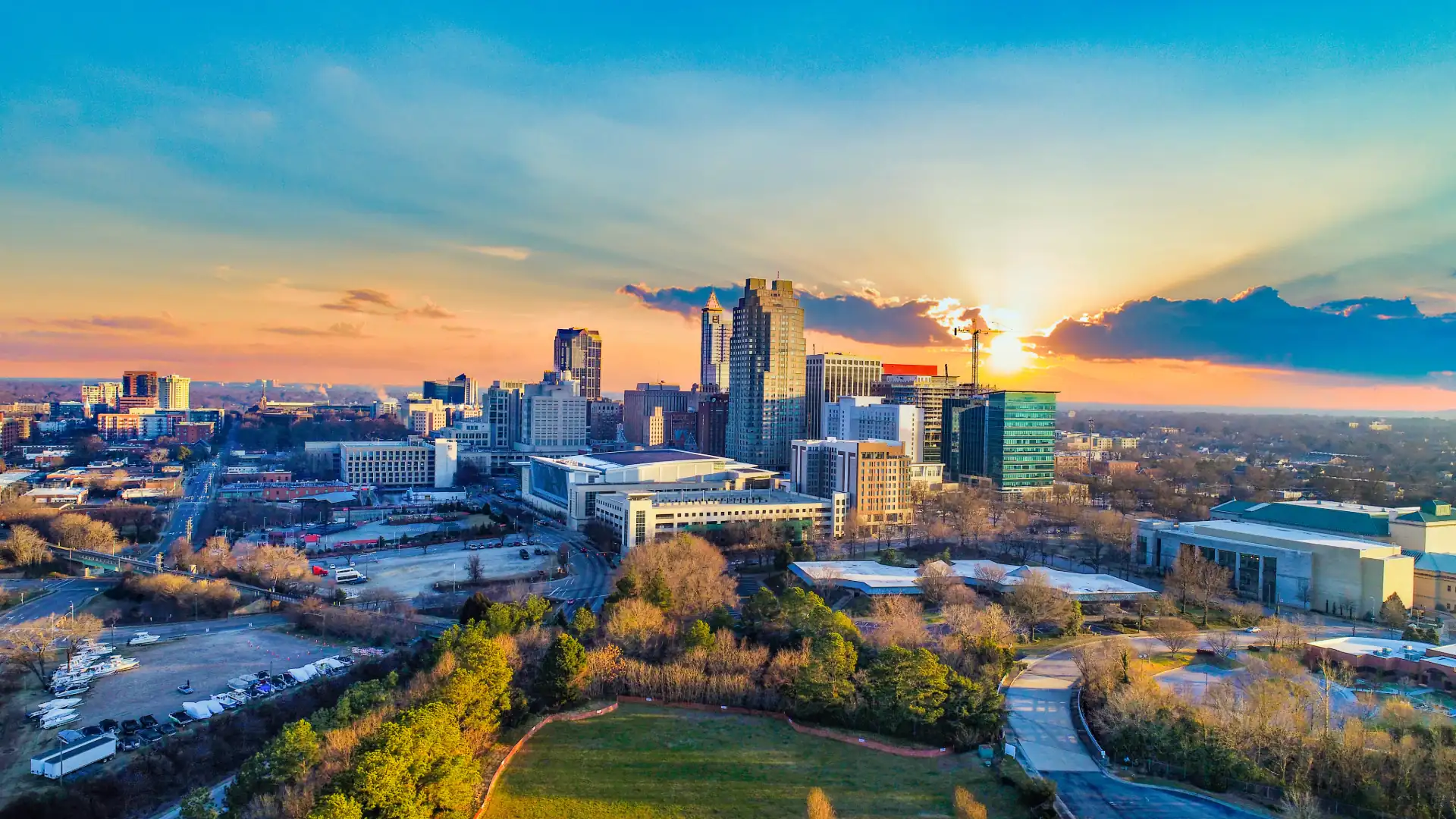 Aerial view of downtown Raleigh, Wake County, North Carolina, with the sun bursting over the skyline
