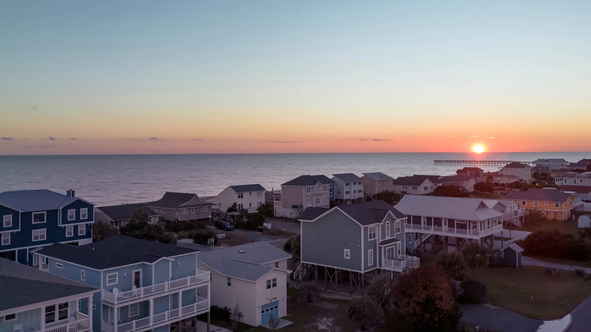 Sunset behind the pier and beachfront homes in Oak Island, Brunswick County, North Carolina
