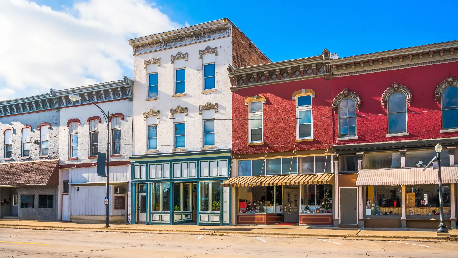 Colorful historic storefronts on a small-town main street under a deep blue sky