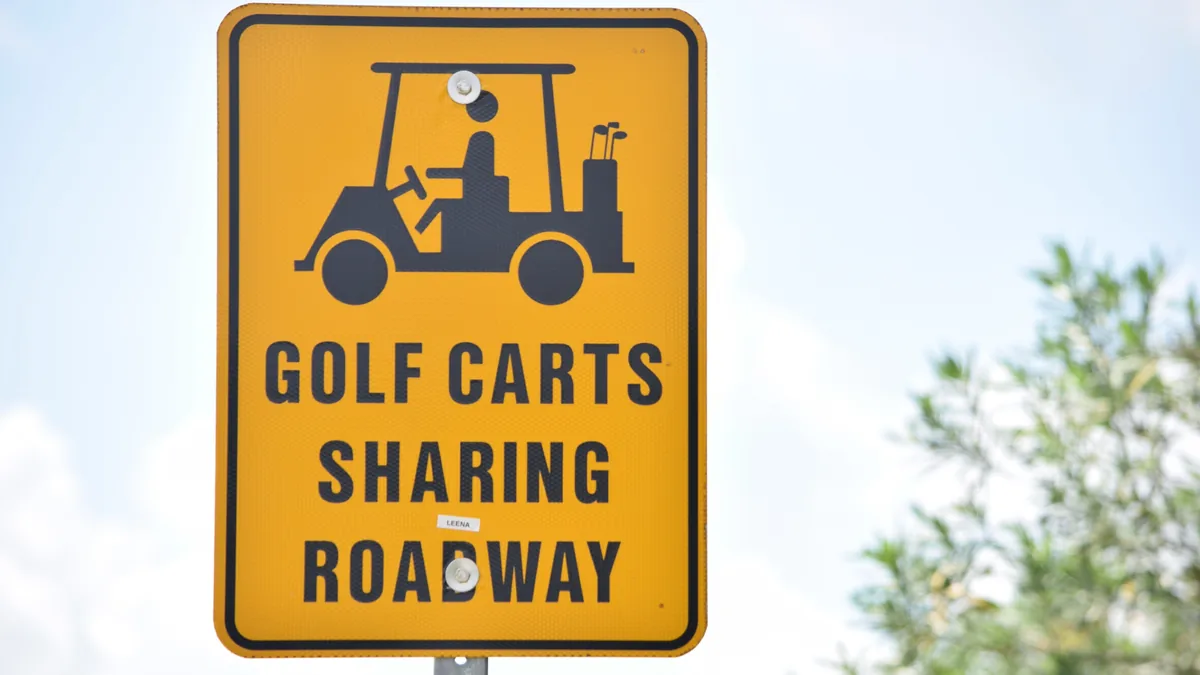 Road sign warning that golf carts share the roadway