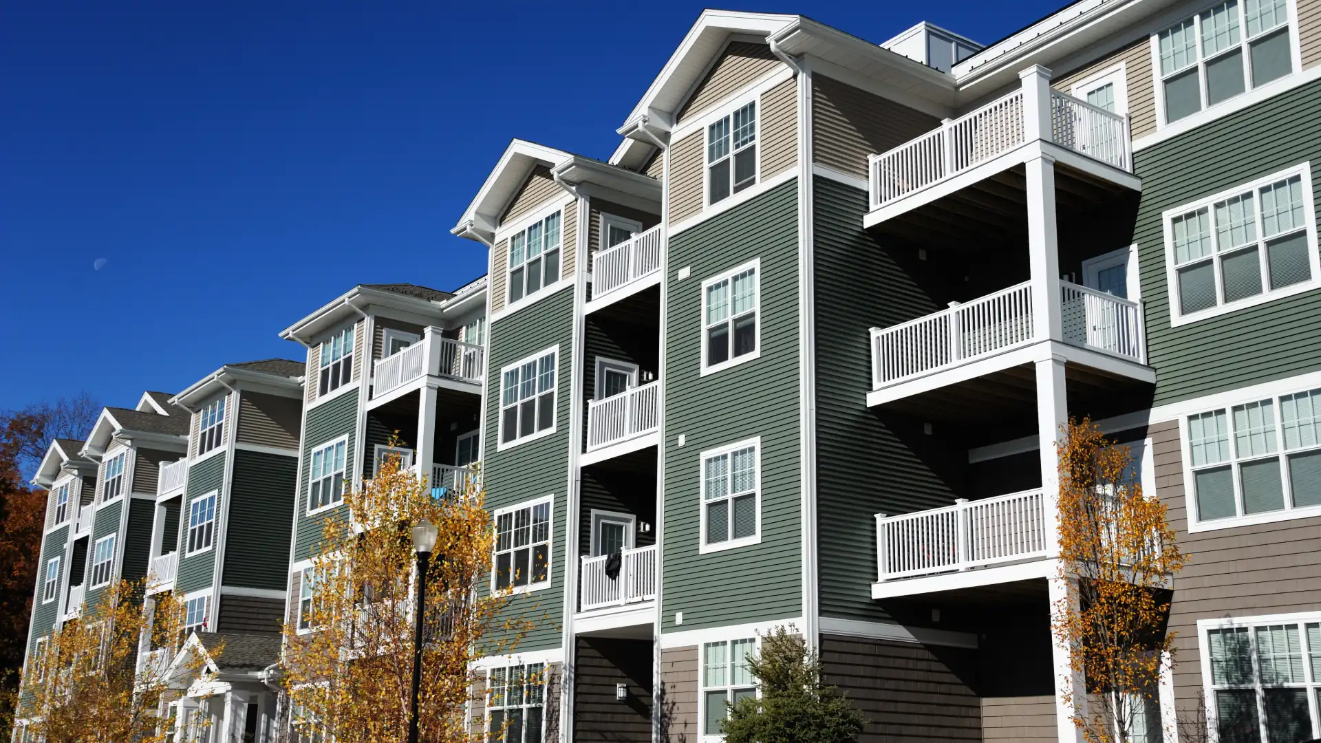 Multi-story residential condo buildings with balconies under a blue sky
