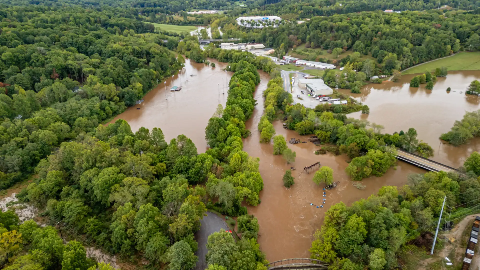 Aerial view of river floodwater from Hurricane Helene covering low ground in western North Carolina