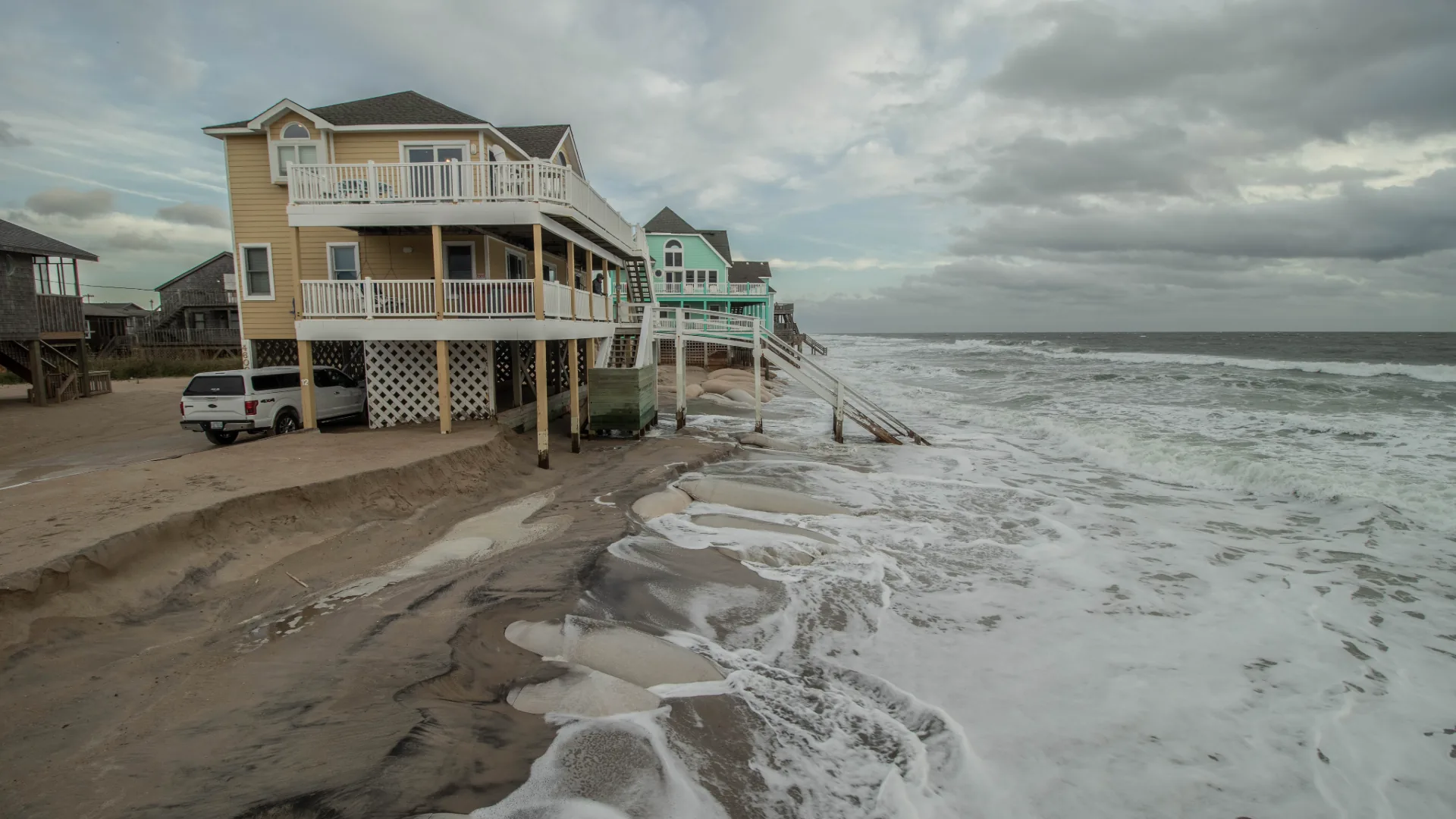 Raised beach homes standing in storm surf on the Outer Banks, North Carolina