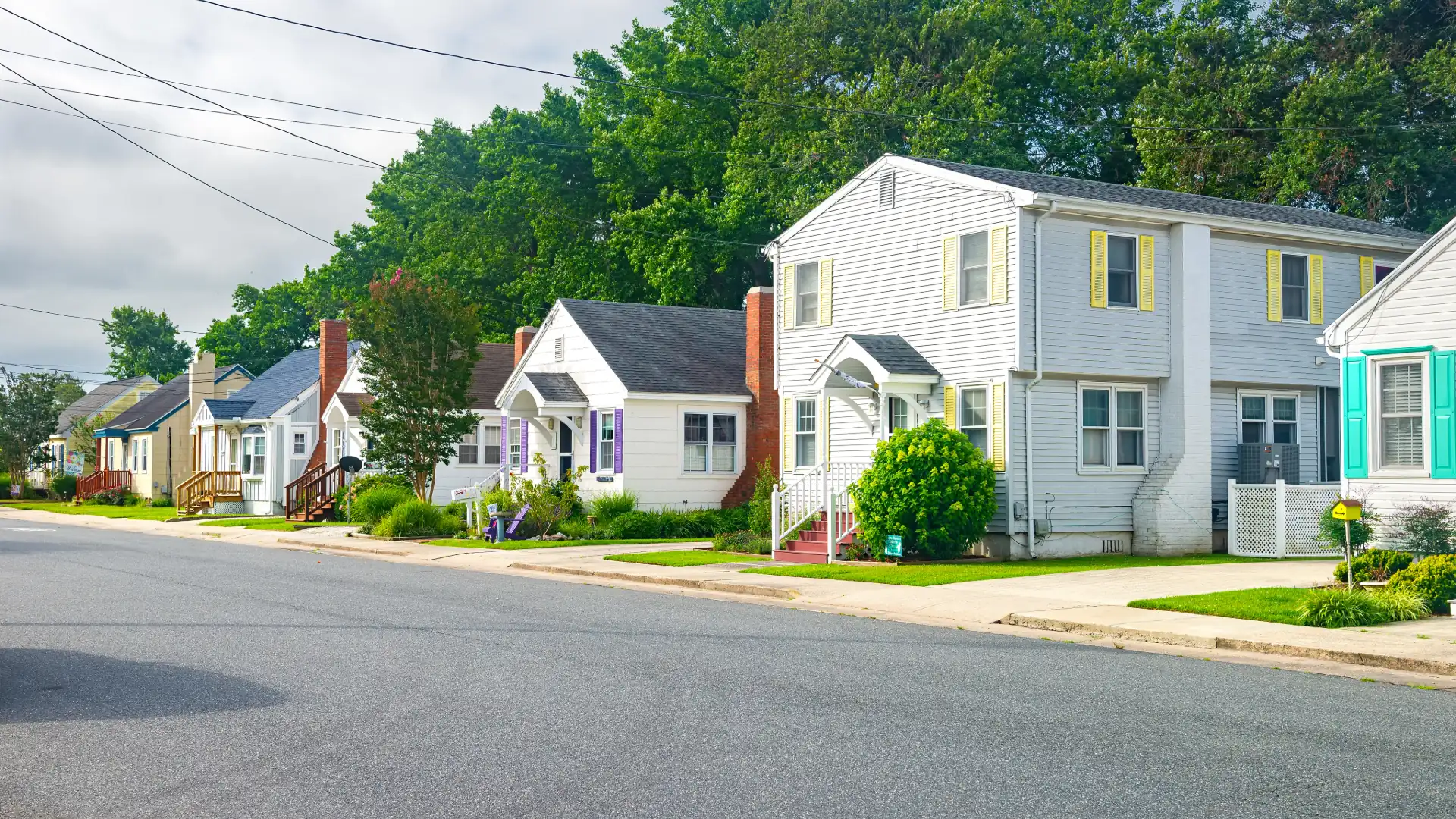 Small-town street with white houses and front porches