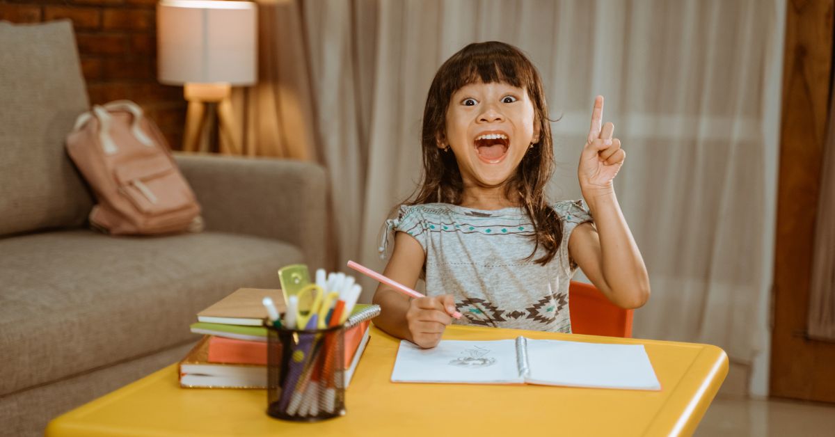 A young girl sits at her desk at home, focused and engaged with an educational activity on her laptop