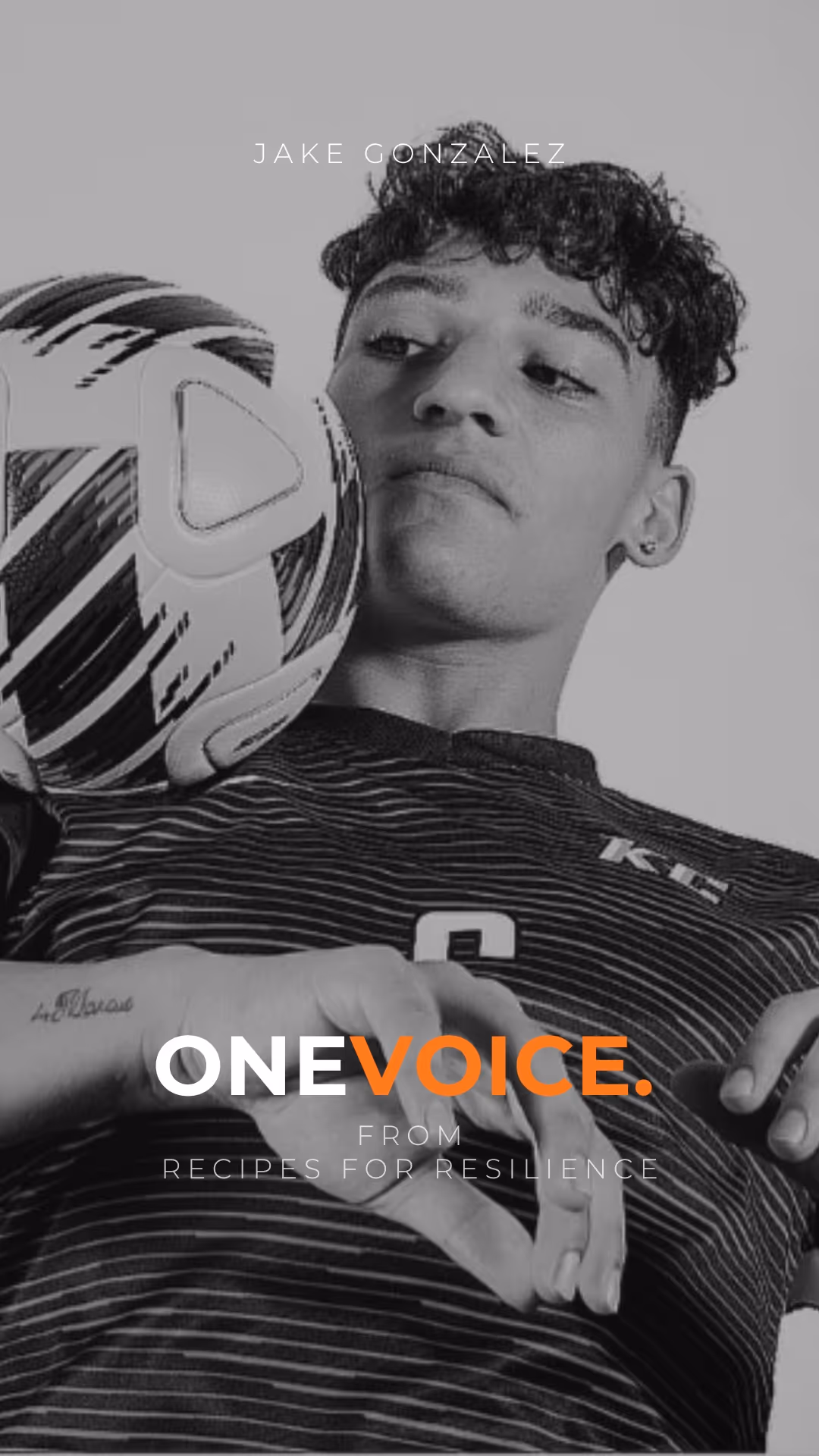 Black and white portrait of a smiling man with glasses and a beard wearing a suit and polka-dot tie in an elegant setting.