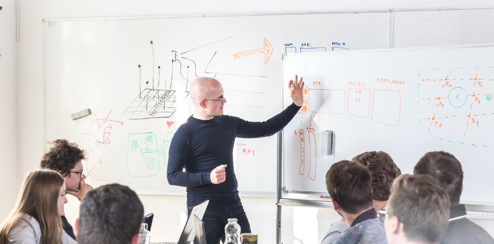 Team leader explaining concepts to colleagues on a whiteboard during a strategy session