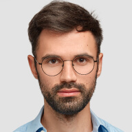 A man wearing glasses and a blue shirt.