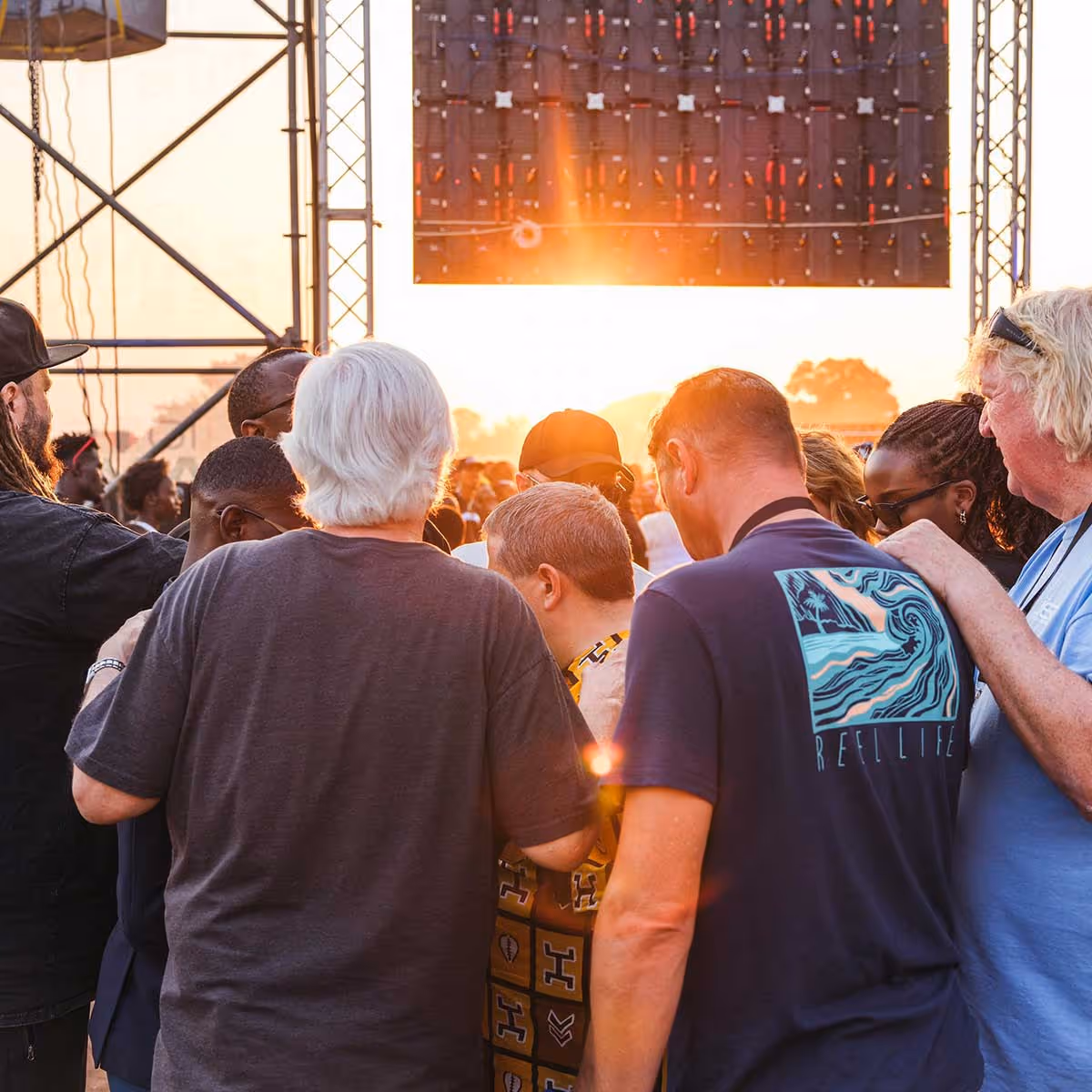 A group of people with their heads bowed together 
