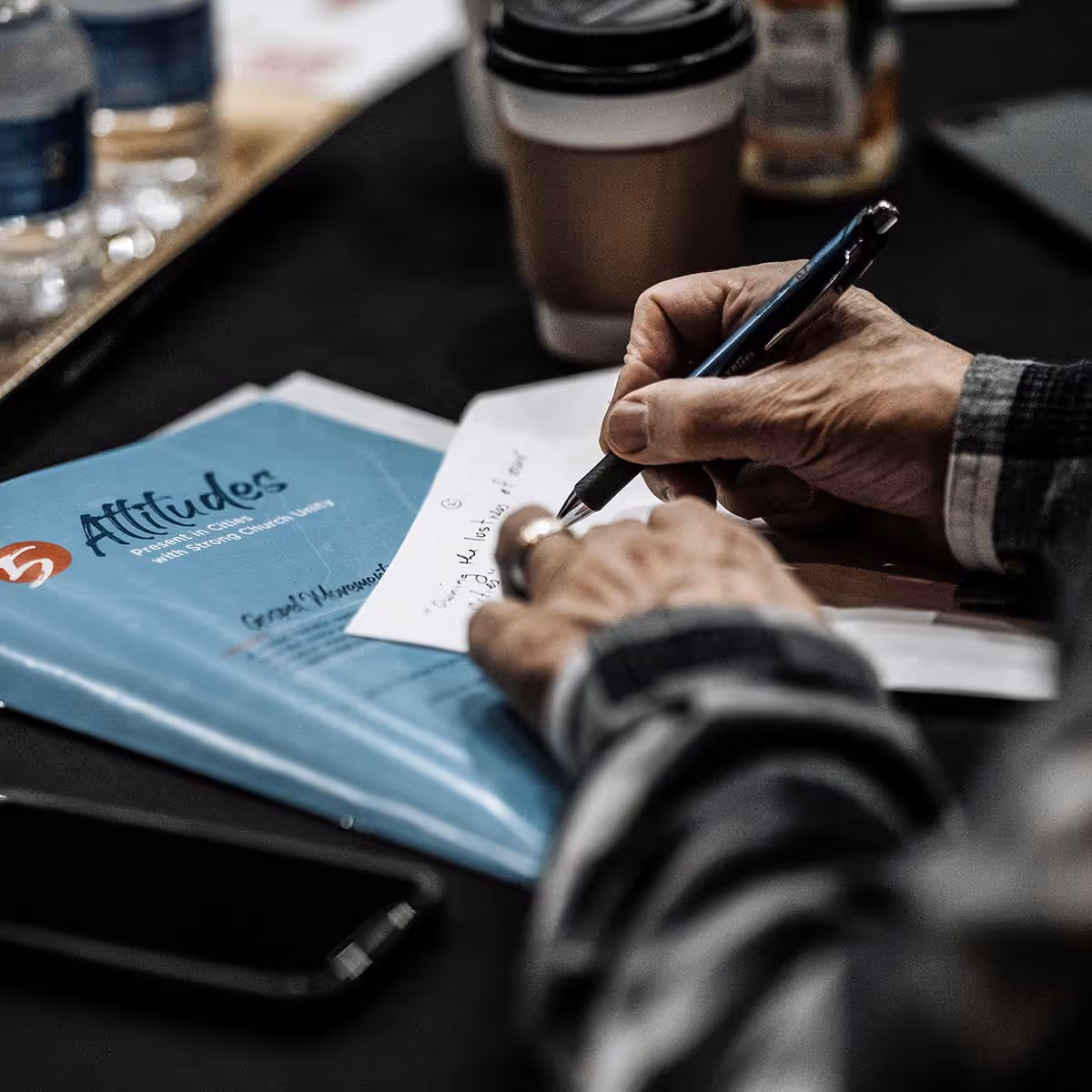 A man taking notes on a piece of paper 