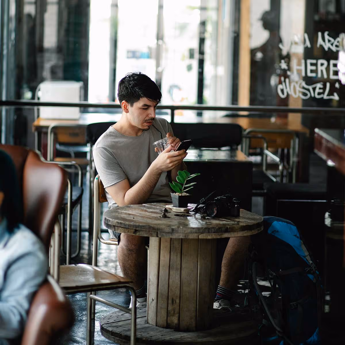 A man on a table looking at his phone 