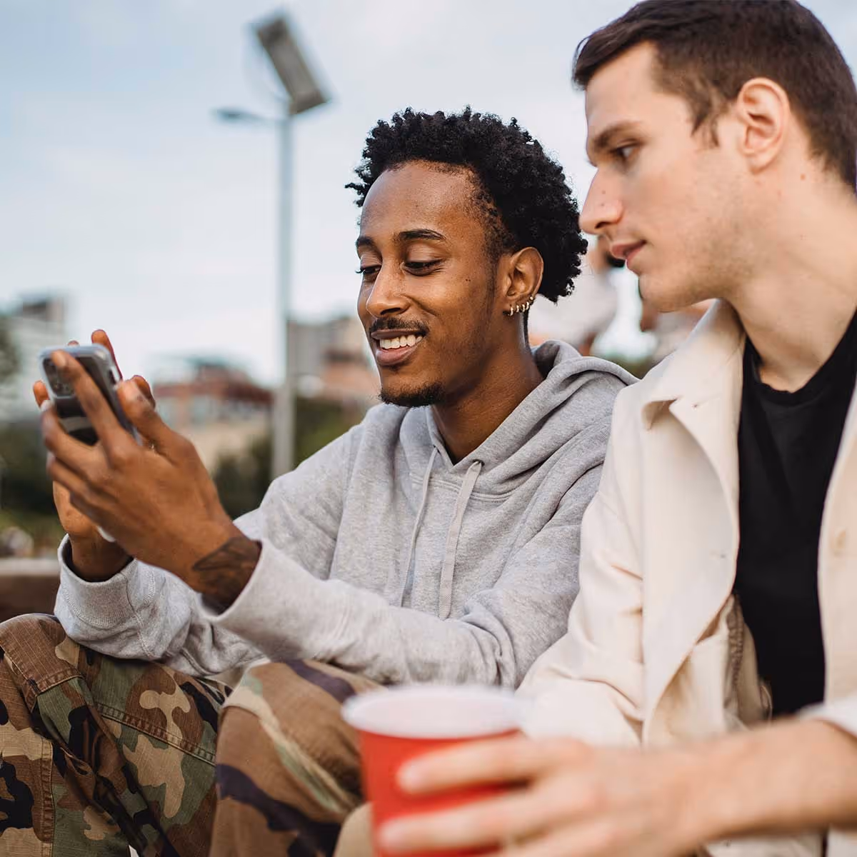 Two men looking at a phone and smiling 